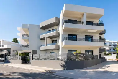 a white apartment building with balconies on a street at Aegean Retreat Luxury Apartment in Rhodes Town
