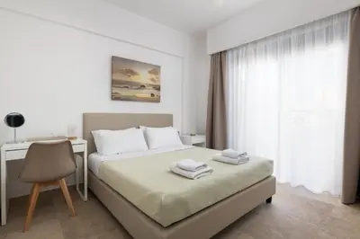 a bedroom with a bed and a desk and a window at Aegean Retreat Luxury Apartment in Rhodes Town