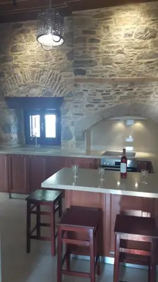a kitchen with a counter with stools and a counter top at Villa Pavlos in Symi