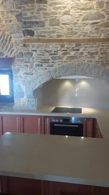 a kitchen with a stove and a stone wall at Villa Pavlos in Symi
