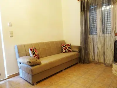 a brown couch in a living room with a window at Nadia's House 1 in Afantou