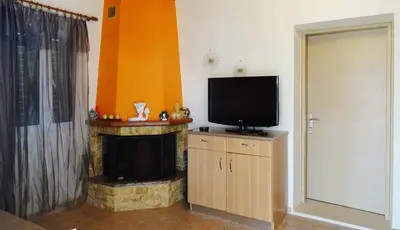 a living room with a television and a fireplace at Nadia's House 1 in Afantou