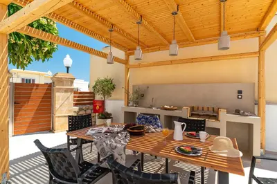 an outdoor patio with a wooden table and chairs at Anastasia Deluxe Studio in Kattavía