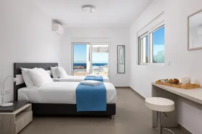 a bedroom with a bed and a view of the ocean at Villa Zoe Blu in Kalathos