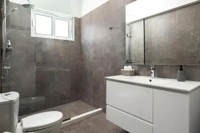 a bathroom with a toilet and a sink and a mirror at Villa Zoe Blu in Kalathos