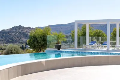 a swimming pool with a view of a mountain at Villa Zoe Blu in Kalathos