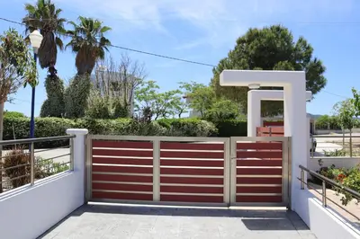 a fence with a red and white gate at Merelia Luxury Guesthouse in Haraki