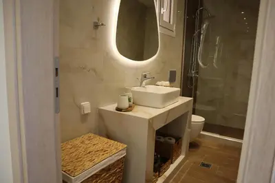 a bathroom with a sink and a toilet and a mirror at Merelia Luxury Guesthouse in Haraki