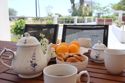 a table with cups and a bowl of oranges and cookies at Merelia Luxury Guesthouse in Haraki