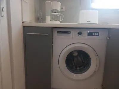 a washing machine in a kitchen with a counter at Summer holidays in Kolimbia