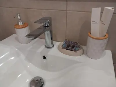 a bathroom sink with a faucet and two trash cans at Summer holidays in Kolimbia