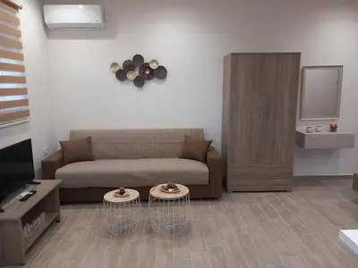 a living room with a couch and two tables at Summer holidays in Kolimbia