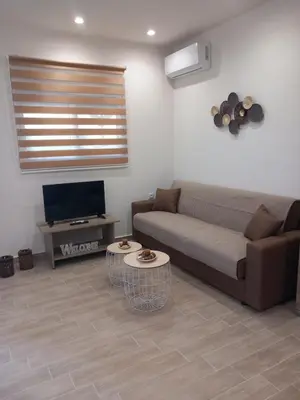 a living room with a couch and a tv at Summer holidays in Kolimbia