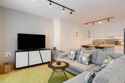 a living room with a couch and a flat screen tv at Mandraki City Center Apartments in Rhodes Town