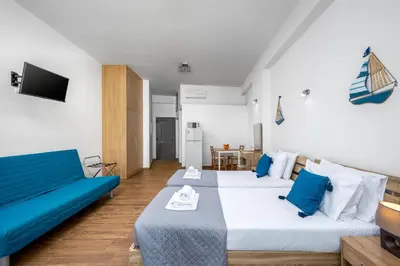 a hotel room with two beds and a television at Stegnale Studios in Archangelos