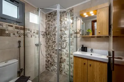 a bathroom with a glass shower and a sink at Stegnale Studios in Archangelos
