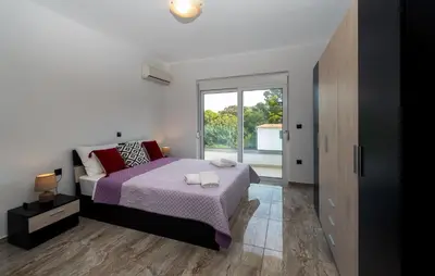 a bedroom with a bed and a large window at Sweet Home Luxury Apartments in Ialyssos