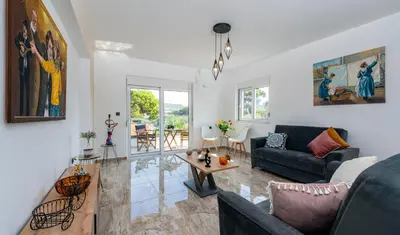 a living room with a couch and a table at Sweet Home Luxury Apartments in Ialyssos