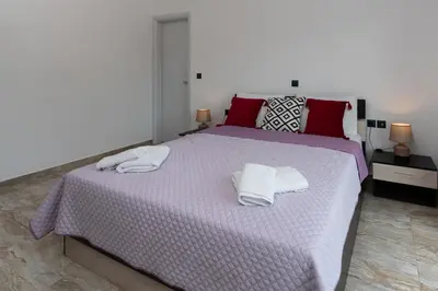 a bedroom with a purple bed with towels on it at Sweet Home Luxury Apartments in Ialyssos