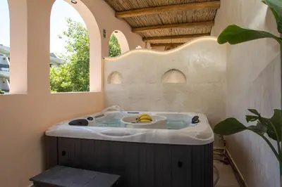 a bath tub with a banana in it with two windows at Saint Zoe Suites in Rhodes Town