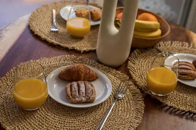 a table with plates of food and glasses of orange juice at Saint Zoe Suites in Rhodes Town