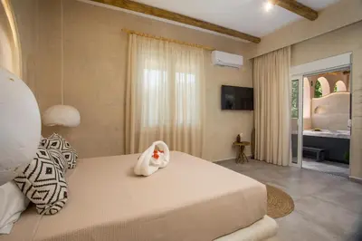 a bedroom with a large bed and a television at Saint Zoe Suites in Rhodes Town