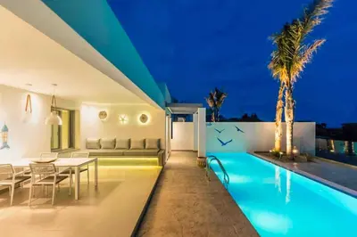 a villa with a swimming pool at night at Villa Anthos Kerasia in Gennadi