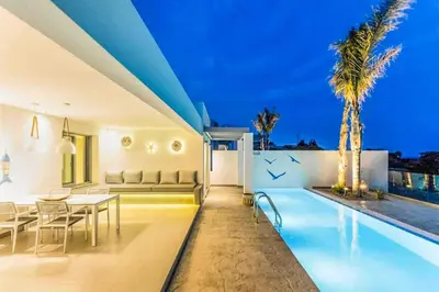 a villa with a swimming pool at night at Villa Anthos Kerasia in Gennadi