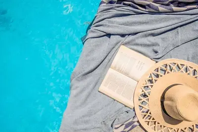 a hat and a book sitting on a bed at Villa Anthos Kerasia in Gennadi