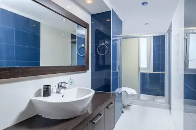 a bathroom with a white sink and a mirror at Paradise Beach II in Kiotari