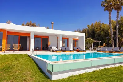 a villa with a swimming pool in front of a house at Villa Seven in Lachania