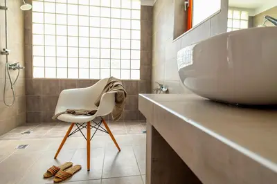 a bathroom with a white sink and a chair at Villa Seven in Lachania