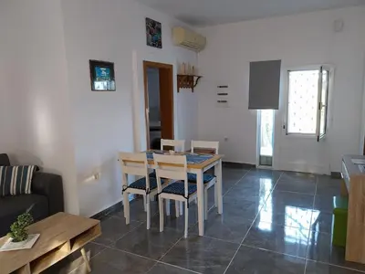 a dining room and living room with a table and chairs at Paradis Studios in Archangelos