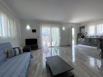 a living room with a couch and a table at Paradis Studios in Archangelos