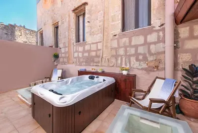 a hot tub on a patio with two chairs at Studio Astero in Rhodes Town