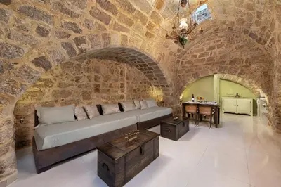 a large room with a bed in a stone wall at Studio Astero in Rhodes Town