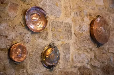 three copper buttons on a brick wall at Studio Astero in Rhodes Town