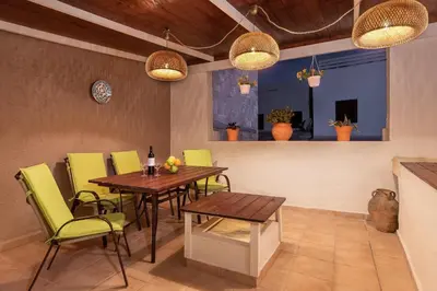 a dining room with a table and yellow chairs at Studio Astero in Rhodes Town