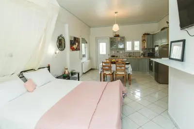 a bedroom with a large bed and a kitchen at Studio Irene, Lindos 10 minutes, Beach 4 minutes in vlicha