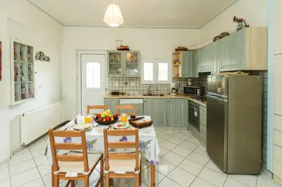 a kitchen with a table with a bowl of fruit on it at Studio Irene, Lindos 10 minutes, Beach 4 minutes in vlicha