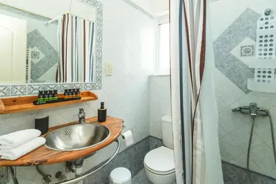 a bathroom with a sink and a toilet and a mirror at Studio Irene, Lindos 10 minutes, Beach 4 minutes in vlicha