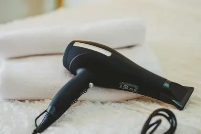 a black hair dryer sitting on a white blanket at Studio Irene, Lindos 10 minutes, Beach 4 minutes in vlicha
