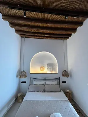 a bedroom with a large bed with a wooden ceiling at Casa Stergia - Village Project in Psinthos