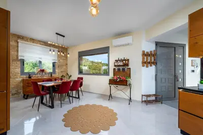 a kitchen and dining room with a table and red chairs at Hideaway Villa in Triánta