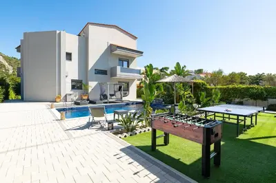 a backyard of a house with a ping pong table at Hideaway Villa in Triánta