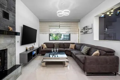 a living room with a brown couch and a fireplace at Hideaway Villa in Triánta