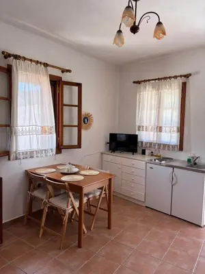 a kitchen with a wooden table and a small table and a kitchen at Sofia’s Studio in Arnítha