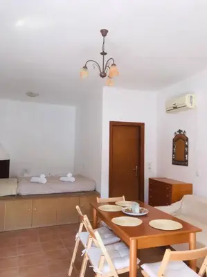 a room with a table and chairs and a bed at Sofia’s Studio in Arnítha