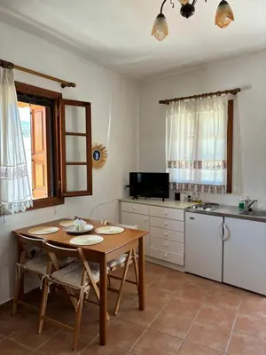 a kitchen with a wooden table and a kitchen with a counter at Sofia’s Studio in Arnítha