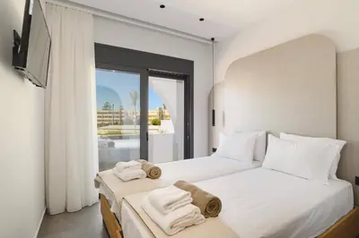 a bedroom with two beds and a large window at Villa Dolce Vita Evelia by Villa Plus in Ialyssos